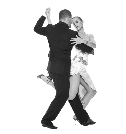 Un uomo e una donna ballano il tango Buena Onda, con l'uomo in completo e la donna con un abito con un alto spacco. Entrambi appaiono concentrati e bilanciati nei loro movimenti.