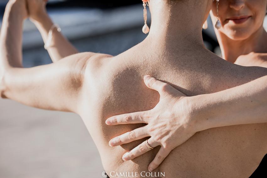 Due persone danzano a stretto contatto, con la mano di una persona appoggiata sulla schiena nuda dell'altra, alla luce del giorno.